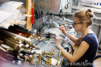 Woman artist making glass jewelry in her worksho Stock Photo