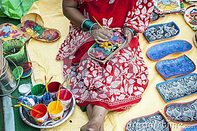 A woman artist painted on a earthen pot in a fair. Editorial Stock Photo