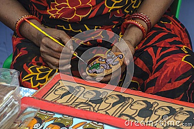 A woman artist painted on a earthen pot in a handicraft fair. Editorial Stock Photo