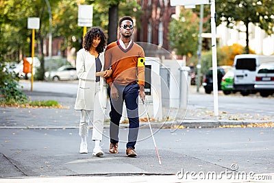 Woman Assisting Blind Man On Street Stock Photo