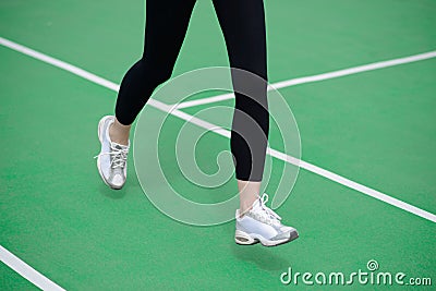 Woman Athlete Runner Feet Running on Green Running Track. Fitness and Workout Wellness Concept. Stock Photo