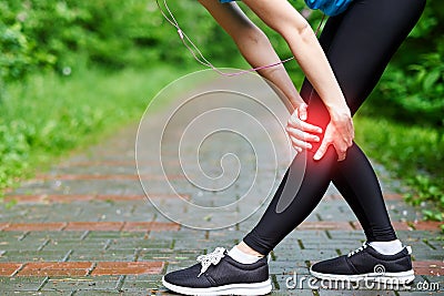 Woman athlete runner touching Knee in pain, fitness woman running in summer park. Healthy lifestyle and sport concept Stock Photo