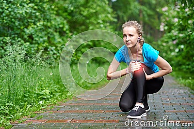 Woman athlete runner touching Knee in pain, fitness woman running in summer park. Healthy lifestyle and sport concept Stock Photo