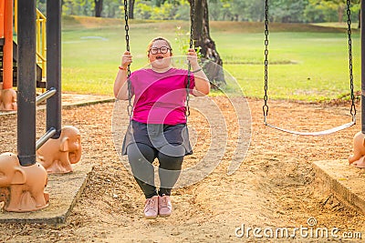 Woman with autistic or down syndrome playing at playground in park Stock Photo