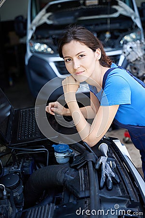 Woman auto mechanic uses a laptop for work Stock Photo