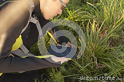 Woman with backpack geocaching with digital compass Stock Photo