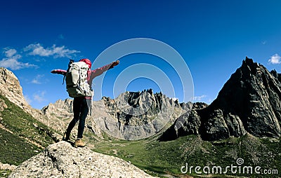 woman with backpack hiking on high altitude mountain top Stock Photo