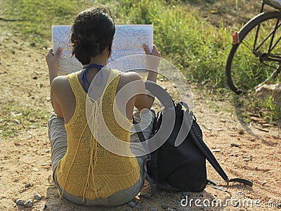 Woman With Backpack And Map Sitting In Dirtroad Stock Photo