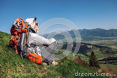 Woman backpacker traveler sitis on the mountain hill with beautiful view on valley Stock Photo