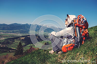 Woman backpacker traveler sitis on the mountain hill with beautiful view on valley Stock Photo