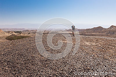 Woman backpacker walking desert. Stock Photo