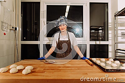 Woman bake pies. Confectioners make desserts. Making buns. Dough on the table Stock Photo