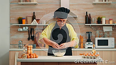 Woman baker cracking eggs Stock Photo