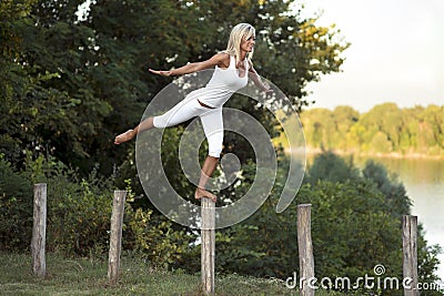 Woman balancing on fence post Stock Photo