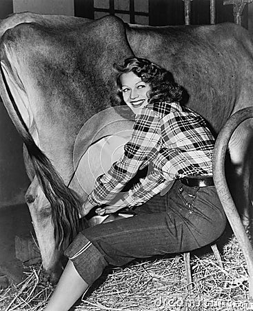 Woman in a barn milking a cow Stock Photo