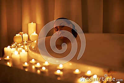 Woman, bathtub and candles for relax treatment at spa or cleaning routine with bubbles for washing, hygiene or wellness Stock Photo