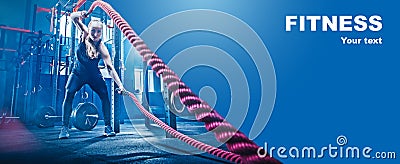 Woman with battle rope battle ropes exercise in the fitness gym. Stock Photo