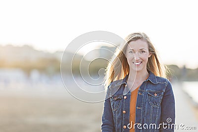 Woman at the beach backlit by the evening sun Stock Photo