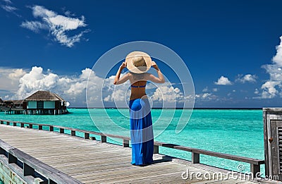 Woman on a beach jetty at Maldives Stock Photo