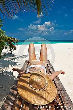 Woman at beach lying on chaise lounge Stock Photo