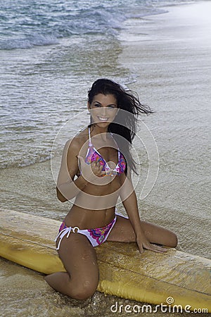 Woman on the beach with surfboard Stock Photo