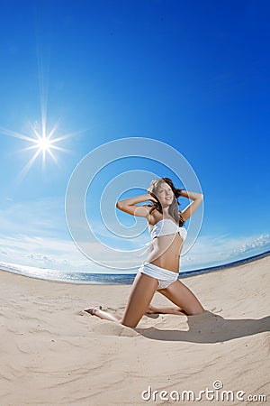 Woman on the beach. Young girl on the sand by sea. Stock Photo