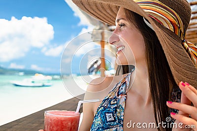 Woman in beachwear enjoying drink in beach cafe at sea Stock Photo