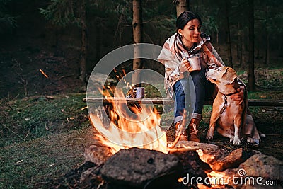 Woman and beagle dog warm near the campfire Stock Photo