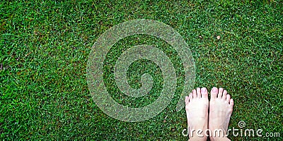 Woman bear feet standing on the lush fresh green grass lawn, top view, connect to nature power concept, receiving negative ions Stock Photo