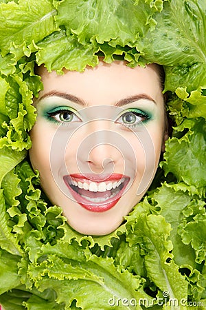 Woman beauty face with green fresh lettuce leaves Stock Photo