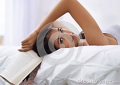 Woman, bed and book portrait in the morning with reading and relax in a home with a smile. Indian female person, bedroom Stock Photo
