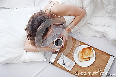 Woman in bed eating breakfast Stock Photo