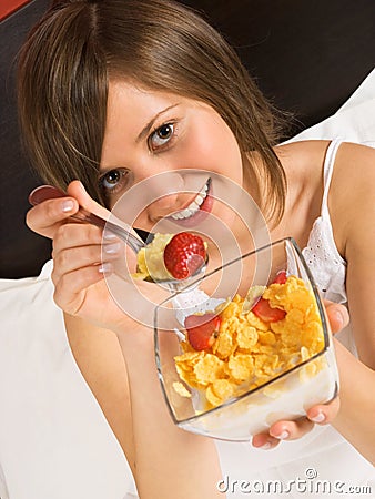 Woman in bed heaving breakfast Stock Photo