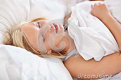 Woman, bedroom and sleeping with face, relax and dreaming in bed, resting and Apartment in morning. Tired, blanket and Stock Photo