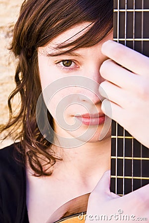 Woman behind guitar fretboard Stock Photo