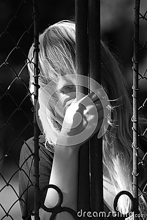 Woman behind metal gate Stock Photo