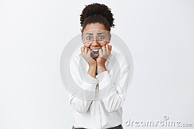 Woman being attacked on dark street, biting fingernails and staring terrified and scared at camera, being frightened of Stock Photo