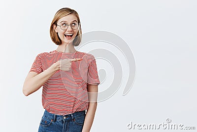Woman being impressed, realising she sits near celebrity in cafe, pointing and looking right curiously with excitement Stock Photo