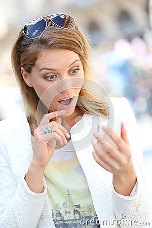 Woman being surprised by sms on the phone Stock Photo