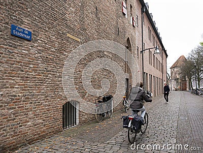 Woman on bicycle in old city of zwolle near ancient town wall Editorial Stock Photo
