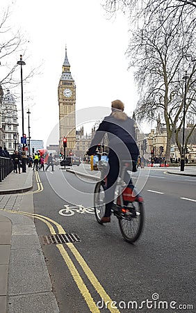 Woman with bicycle riding in central London city. Big Ben in background Editorial Stock Photo