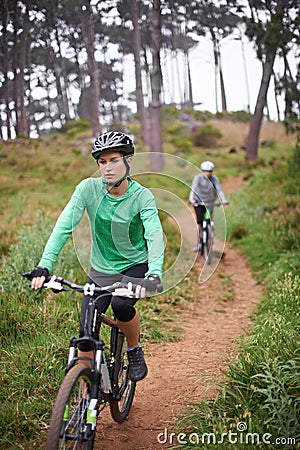 Woman, bike and cycling outdoor on trail for exercise, workout or adventure in forest with fitness. People, cyclists and Stock Photo