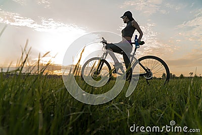 Woman bike sunset. exercise at sunset Stock Photo