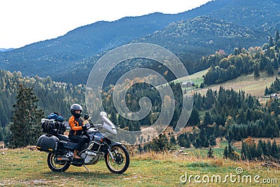 Woman biker with big adventure motorbike, motorcyclists vacation, world traveler, long road trip on two wheels. autumn day. Stock Photo