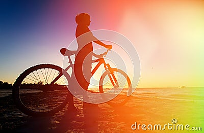 Woman biking at sunset Stock Photo