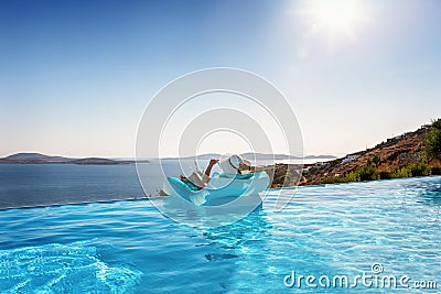 Woman relaxes on a float under the Mediterranean sun Stock Photo