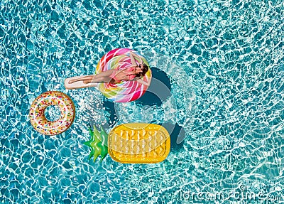 Woman in bikini relaxes on a lolli pop shaped swimming pool float Stock Photo