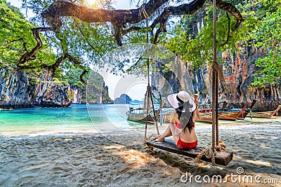 Woman in bikini relaxing on swing at Ko lao lading island, Krabi, Thailand Stock Photo