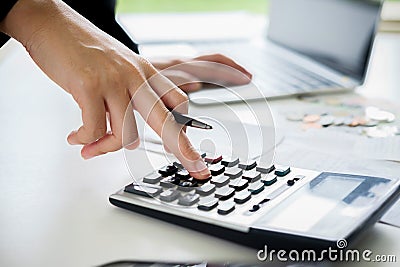 Woman with bills and calculator. Woman using calculator to calculate bills at the table in office. Calculation of costs. Stock Photo