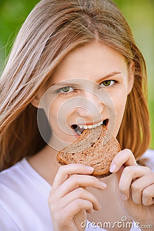 Woman bites piece of bread Stock Photo